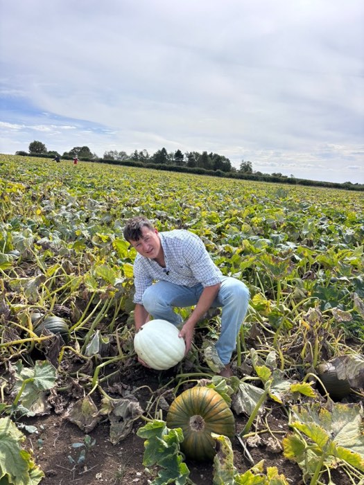 Holding a pale ghost pumpkin picked from the field